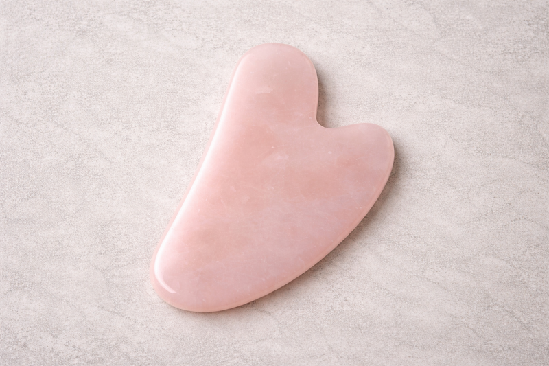 Pink heart-shaped stone on a light gray background
